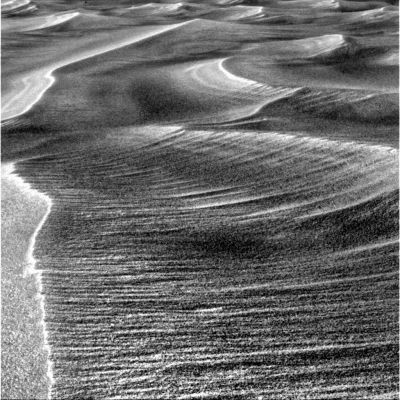 Side-Winders (detail mgnf) - 1
Solo su questa immagine potremmo spendere pagine e pagine di commenti senza arrivare a nulla e dunque, anzichè speculare a vuoto, Vi diamo uno spunto di riflessione: guardate questi Side-Winders e poi osservate le tracce lasciate dalle ruote del Rover sulle sabbie di Meridiani.
Laddove i Side-Winders sono (rectius: appaiono) lisci e leggeri, con le loro linee morbide e sinuose che ci fanno pensare a sabbie e polveri sottilissime che il vento (eventaulmente in concorso con altri fattori che non conosciamo) modella a piacere, i solchi lasciati dalle ruote del Rover ci mostrano - come avete visto in passato e come vedrete bene nei frames successivi - sabbie estremamente compatte, miste a pietrisco e, forse, a cristalli di un qualche tipo.

Un contrasto che fa pensare, non credete?!?
Parole chiave: Mars rocks, sand and debris