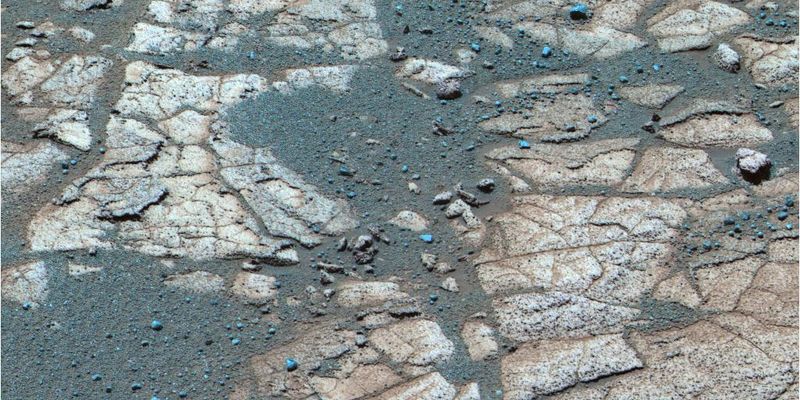 False color view of Meridiani's "Outcrops" - Sol 552
After months spent roving across a sea of rippled sands, Opportunity reached an outcrop in August 2005 and began investigating exposures of sedimentary rocks, intriguing rind-like features that appear to cap the rocks and cobbles that dot the Martian Surface locally. Opportunity spent several Soles analyzing a feature called "Lemon Rind" a thin surface layer covering portions of outcrop rocks poking through the sand north of Erebus Crater. In images from the PanCam, Lemon Rind appears slightly different in color than surrounding rocks. It also appears to be slightly more resistant to wind erosion than the outcrop's interior. To obtain information on how this surface layer (or weathering rind) may have formed and how it compares to previously analyzed outcrops, the Rover is using the MI, the APX-rS and the Moessbauer Spec.r to analyze surfaces that have been brushed and ground with the RAT. Scientists will compare these measurements with similar measurements made on the underlying rock material. This is a false-color composite generated by draping enhanced red-green-blue color from the panoramic camera's 753-nanometer, 535-nanometer and 482-nanometer filters over a high-fidelity violet, 432-nanometer-filter image. The image was acquired on martian day, or sol 552 (Aug. 13, 2005) around 11:55 a.m. local true solar time. In this representation, bright sulfur-bearing sedimentary rocks appear light tan to brown, depending on their degree of dust contamination, and small dark "blueberries" and other much less dusty rock fragments appear as different shades of blue. Draping the color derived from the blue to near-infrared filters over the violet filter image results in a false color view with the sharpest color and morphology contrasts.
Parole chiave: Martian Paving