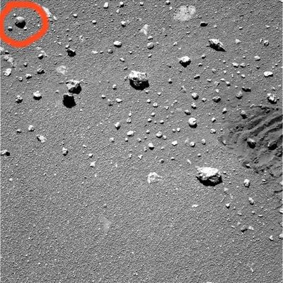 The terrain near Erebus (detail mgnf) - Sol 555
Questa immagine PanCam del Sol 555 di Opportunity sembrava, ad una prima e sommaria occhiata, un'immagine "insignificante". Inutile dire che ci sbagliavamo alla grande...Questo frame, infatti, contiene un dettaglio che, a nostro parere, è di grandissima importanza. Sino ad ora abbiamo incontrato svariate rocce, ora più grandi ed ora più piccole (ma sempre di dimensioni consistenti), che presentavano "buchi" sulla loro superficie. Questi "buchi", del tutto ignorati in sede di ricerca NASA ed ESA ufficiale, noi abbiamo speculato che sarebbero potuti essere delle "via d'ingresso e di uscita" da un Marte sotterraneo, nascosto agli occhi delle nostre telecamere. Ma ora guardate il piccolo e perfettamente sferico "buchetto" che si vede sulla pietra cerchiata in rosso: curioso, vero? 
Specie se considerate che, ad una nostra - ovviamente approssimativa - stima, la pietra che presenta il buco non dovrebbe essere lunga più di 4 o 5 cm.
Domanda: cosa può aver creato un buco così piccolo e dai contorni così precisi?
Parole chiave: Mars rocks, sand and debris