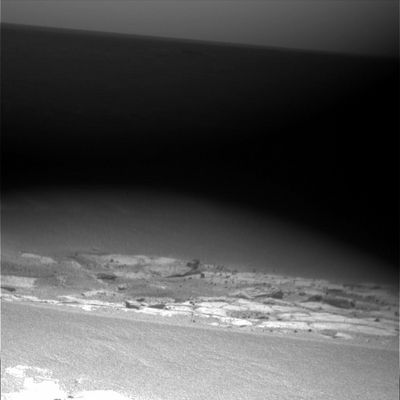 Meridiani's dawn (2) - Sol 673
E se il piccolo "lago di luce" che circonda il Rover fosse opera di "faretti", accesisi per illuminare i dintorni e scattare qualche frame in attesa che si fosse fatto giorno? 
Noi non siamo a conoscenza dell'esistenza di simili "faretti", però non ci siamo mai intrattenuti troppo sulle caratteristiche tecniche dei MER Spirit ed Opportunity e quindi l'informazione potrebbe anche esserci sfuggita. 
Ad ogni modo, se questi "faretti" esistessero realmente, allora il curioso (e "tenebroso") effetto di illuminazione negli immediati paraggi del Rover mentre il resto del paesaggio giace ancora nel buio sarebbe spiegato.

Original caption:"Left Pan-Cam Non-linearized Full frame EDR acquired on Sol 673 of Opportunity's mission to Meridiani Planum at approximately 08:24:08 MLT. Camera commanded to use Filter 4 (601 nm)".
Parole chiave: Martian Dawn - Meridiani Planum