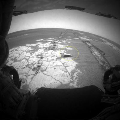 A "squared stone" in the sand - Sol 767
Un'interessante segnalazione del nostro Amico (e recente Socio Lun-Ex-It) Gianluigi Barca: cerchiata in giallo, la porzione superiore di una roccia apparentemente regolare e squadrata emerge dalle sabbie di Meridiani, a pochi metri dalla Front HazCam di Opportunity. 
A questo riguardo la Scuola del Prof. R. Hoagland, come sapete, non fa sconti a nessuno: "squadratura = artificialit�", ci dicono. 
Noi, in tutta onest� (come sempre), non vediamo le cose in questo modo. L'esistenza di angoli retti, di squadrature e, talvolta, di profili regolari e/o semi-regolari, come sapete, non � un evento rarissimo in Natura (chi ha mai pensato che quasi tutti i tipi di quarzo, o la pirite cubica, o quei gessi cristallini conosciuti come "Rose" e "Gigli del Deserto" - tanto per parlare di minerali aventi delle forme naturalmente squadrate - e talora assai bizzarre - fossero per ci� solo dei "manufatti"?).
Ci� non toglie, tuttavia, che le rocce di Marte sono davvero "strane". 
Ma strane non significa - necessariamente - artificiali. Questa roccia squadrata � - appunto - "strana" ed i processi geologici (e non) che l'hanno resa cos� come noi oggi la vediamo sono difficili da immaginare. Un suggerimento: facciamo come il nostro Amico Gianluigi. Individuiamo le "stranezze", isoliamole e poi cerchiamo di studiarle, senza parlare subito - come fanno i nostri Amici d'Oltremare - di artificialit� e di manufatti. La Ricerca vera non si fa partendo da una conclusione e poi ricostruendo la realt� a ritroso, cercando di adattarla (forzandola) a quella conclusione (Metodo Hoagland); la Ricerca vera si fa raccogliendo dati e quindi operando analisi e confronti. Alla fine, forse, potremmo anche rimanere delusi (qualche volta), ma noi riteniamo che sia meglio patire delle delusioni dopo aver studiato ed operato con metodo e pragmatismo, piuttosto che coltivare entusiasmi fondati solamente su speculazioni e congetture.
Parole chiave: Mars Rocks, Sand and Debris - Anomalous Surface Feature