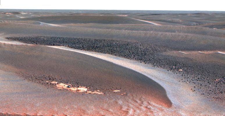 Meridiani's Portrait (1) - false (?) colors
As NASA's MER Opportunity continues to traverse from Erebus Crater toward Victoria Crater, the Rover navigates along exposures of bedrock between large, wind-blown ripples. Along the way, scientists have been studying fields of cobbles that sometimes appear on trough floors between ripples. They have also been studying the banding patterns seen in large ripples. This view, obtained by Opportunity's PanCam on the Rover's 802nd Sol of exploration (April 27, 2006), is a mosaic spanning about 30°. It shows a field of cobbles nestled among wind-driven ripples that are about 20 cm (8") high. The origin of cobble fields like this one is unknown. The cobbles may be a lag of coarser material left behind from one or more soil deposits whose finer particles have blown away. The cobbles may be eroded fragments of meteoritic material, secondary ejecta of Mars rock thrown here from craters elsewhere on the surface, weathering remnants of locally-derived bedrock, or a mixture of these. Scientists will use the panoramic camera's multiple filters to study the rock types, variability and origins of the cobbles. 

This is a false-color rendering that combines separate images taken through the panoramic camera's 753-nanometer, 535-nanometer and 432-nanometer filters. The false color is used to enhance differences between types of materials in the rocks and soil.

Parole chiave: Mars Panorama - Dunes, Ripples and Outcrops - Meridiani Planum