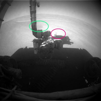 Round shadow on the ground and a missing part of the RA - Sol 814
Cerchiatura Verde: ancora il rilievo anomalo di cui al frame precedente

Cerchiatura Fucsia: l'oggetto metallico che pare galleggiare nel vuoto è solo una componente del Robotic Arm (RA) e su questo non ci sono dubbi (potrebbe trattarsi del MI), ma l'immagine - se guardate con attenzione - sembra essere stata "tagliata", in un suo punto. 
A dire il vero, e tanto per non cercare sempre di creare "dubbi&misteri" (non è nel nostro costume), potrebbe darsi che l'effetto "taglio" dipenda dalla sovraesposizione di una componente metallica di supporto del RA la quale, colpita in pieno dai raggi di un Sole bel alto sull'orizzonte (la foto è delle 13:39 MLT), è stata (come dicono alla NASA) "washed out" (lavata via/eliminata) dal frame.

Può essere.
Parole chiave: Martian Surface - Controversial