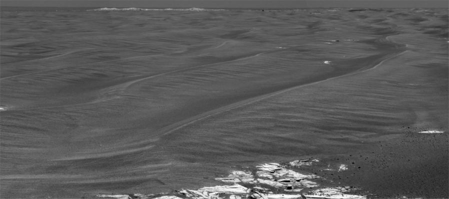 Beagle Crater (normal) - Sol 855
Caption NASA originale:"This imagery from the PanCam on NASA's MER Opportunity shows the outcrop-rimmed "Beagle Crater" appearing on the horizon as Opportunity approaches it. The stretched version (see the following frame) is vertically stretched to make horizon details easier to see. The un-stretched version (such as this one) has normal proportions. The image is a mosaic of frames taken during Opportunity's 855th Martian day, or Sol (such as June 20, 2006). 

Beagle Crater is 35 meters (about 115 feet) in diameter. The Opportunity science and engineering teams hope to have the Rover visit it on the way to Victoria Crater. Beagle Crater was 310 meters (about 1.107 feet) away from Opportunity when this picture was taken. Even at this distance, blocks of ejecta can be seen around the prominent, raised rim of Beagle crater, suggesting that it may be among the youngest craters visited by Opportunity".
Parole chiave: Martian Panorama - Beagle Crater