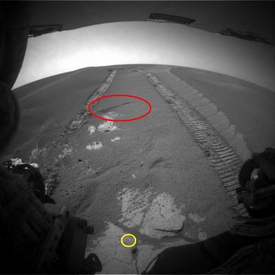 Martian Sandglasses - Sol 870
Ed ecco, sempre individuata dal nostro Ricercatore Dr Gianluigi Barca, una vera e propria "Clessidra Marziana" e cioè, in accordo a quanto ipotizato dal Dr Alessandro Pullini - lo Scopritore di questo fenomeno ed il primo Ricercatore che ne ha fornito una spiegazione logica ed accettabile - una (modesta) zona della superficie Marziana la quale, "disturbata" - nelle sue immediate profondità - dal passaggio del Rover, ha avviato un mini-processo di assestamento sotterraneo ed ha iniziato, di conseguenza, ad inghiottire una porzione delle sabbie superficiali (per una spiegazione migliore e più accurata del fenomeno, si veda l'articolo del Dr Pullini, pubblicato nella Sezione "TruePlanets").

Cerchiatura Gialla: con ogni probabilità, si dvrebbe trattare di un semplice photoartifact.
Parole chiave: Martian Surface - Martian Sandglasses - Meridiani Planum
