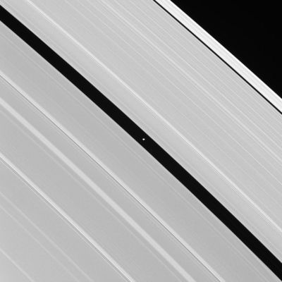 Pan running in his "lane"
Saturn's moon Pan occupies the Encke Gap at the center of this image, which also displays some of the A-Ring's intricate wave structure. Pan is 26 Km (about 16 miles) across. 
The two most prominent bright banded features seen on the left side of the image are Spiral Density Waves, which propagate outward through Saturn's Rings. The bright crests represent areas with higher ring particle densities. 
The image was taken in visible green light with the Cassini spacecraft narrow-angle camera on Aug. 1, 2005, at a distance of approx. 794.000 Km (about 493.000 miles) from Pan. The image scale is 5 Km (such as 3 miles) per pixel.
Parole chiave: Saturn's Moons - Pan