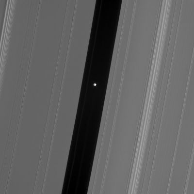 A "Bright Pearl" in the Darkness: Pan in the Gap
Caption NASA originale:"This Cassini spacecraft view of Pan in the Encke Gap shows hints of detail on the moon's dark side, which is lit by Saturnshine -- sunlight reflected off Saturn. 
Pan (26 Km, or 16 miles across) cruises the Encke Gap (325 Km, or 200 miles wide) with several faint ringlets. 
This view looks toward the lit side of the Rings from about 52° below the Ring-Plane. The sunlit portion of Pan is partly overexposed. 

The image was taken in visible light with the Cassini spacecraft narrow-angle camera on Oct. 27, 2006 at a distance of approx. 385.000 Km (about 239.000 miles) from Pan and at a Sun-Pan-spacecraft, or phase, angle of 86°. Image scale is roughly 2 Km (1,4 miles) per pixel".
Parole chiave: Saturn's Moons - Pan