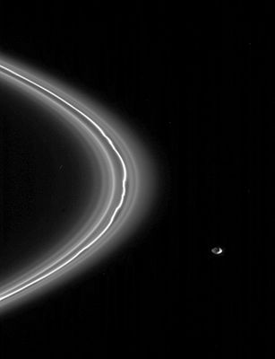 Pandora and the F-Ring
Caption NASA originale:"The shepherd moon, Pandora, is seen here alongside the narrow F-Ring that it helps maintain in the right equlibrium. 
Cassini obtained this view from about 4° above the ringplane. Captured here are several faint, dusty ringlets in the vicinity of the F-Ring core. 
The ringlets do not appear to be perturbed to the degree seen in the core. 
The appearance of Pandora here is exciting, as the moon's complete shape can be seen, thanks to reflected light from Saturn, which illuminates Pandora's dark side; also the hint of a crater is visible on the dark side of the moon. 
The image was taken in visible light with the Cassini spacecraft narrow-angle camera on May 4, 2005, at a distance of approx. 967.000 Km (such as approx. 601.000 miles) from Pandora and at a Sun-Pandora-spacecraft angle of 117°. The image scale is 6 Km per pixel".
Parole chiave: Saturn's Moons - Pandora