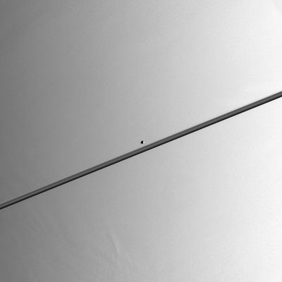 Pandora, from 1,3 MKM
While close to Saturn in its orbit, Cassini stared directly at the Planet to find Saturn's moon Pandora in the field of view. The F-Ring shepherd moon is gliding towards the right in this scene. The F-Ring is thinly visible just above the main rings. Pandora is 84 Km (about 52 miles) across. 
Near the lower left, some variation in the height of Saturn's cloud tops can be detected. This effect is often visible near the terminator (such as the day and night boundary), where the Sun is at a very low angle above Saturn's horizon. 
The image was taken in visible light with the Cassini spacecraft narrow-angle camera on July 16, 2005, at a distance of approx. 1,3 MKM (about 800.000 miles) from Saturn. 
The image scale is about 8 Km (about 5 miles) per pixel on Saturn and about 6 Km (about 4 miles) per pixel on Pandora.
Parole chiave: Saturn and Pandora