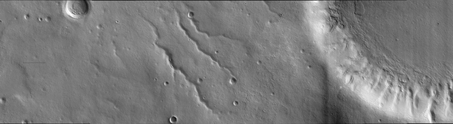 Bosporos Rupes
This image was taken in the mid-latitudes of Mars' Southern Hemisphere near the giant Argyre Impact Basin. It is located just to the West of a prominent scarp known as Bosporos Rupes. The left side of the image shows cratered plains. Some of the craters are heavily mantled and indistinct, whereas others exhibit sharp rims and dramatic topography. The largest crater in this half of the image is about 2,5 Km wide. Mounds and ridges, which may be remnants of an ice-rich deposit, are visible on its floor. Three sinuous valleys occupy the center of the image. Valleys such as these were first observed in data returned by the NASA Mariner 9 spacecraft, which reached Mars in 1971. The right side of the image shows part of an impact crater that is approx. 20 Km in diameter. The furrowed appearance of the crater's inner wall suggests that it has been extensively modified, perhaps by landslides and flowing water. Like other craters in the area, the floor of this crater has a rough and dissected texture that is often attributed to the loss of ice-rich material. 

This image was taken by the High Resolution Imaging Science Experiment (HiRISE) camera onboard NASA's Mars Reconnaissance Orbiter spacecraft on March 24, 2006. The image is centered at 40,64° South Latitude, 303,49° East Longitude. The image is oriented such that North is 7° to the left of up. The range to the target was 2.044 Km (about 1.270 miles). At this distance the image scale is 2,04 mt (6,69 feet) per pixel, so objects as small as 6,1 mt (20 feet) are resolved. In total this image is 40,90 Km (about 25,41 miles) or 20.081 pixels wide and 11,22 Km (such as 6,97 miles) or 5.523 pixels high. The image was taken at a Local Mars Time of 07:30 and the scene is illuminated from the upper right with a solar incidence angle of 81,4° (this meaning that the Sun was about 8,6° above the horizon). 

Parole chiave: Mars from orbit - Bosporos Rupes