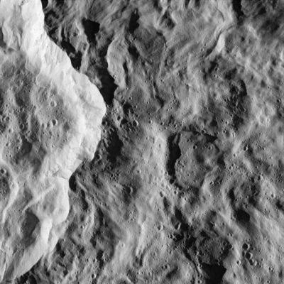 Rhea's "Ray Crater" (alias the "Great White Splat") and scarps from 511 Km
(...) Cassini spacecraft snapped this image of the Eastern rim of Saturn's moon Rhea's bright, Ray Crater. The impact event appears to have made a prominent bright splotch on the Leading Hemisphere of Rhea. Because Cassini was traveling so fast relative to Rhea as the flyby occurred, the crater would have been out of the camera's field of view in any earlier or later exposure. The crater's total diameter is about 50 Km, but this rim view shows details of terrains both interior to the crater and outside its rim. The prominent bright scarp, left of the center, is the crater wall, and the crater interior is to the left of the scarp. The exterior of the crater (right of the scarp) is characterized by softly undulating topography and gentle swirl-like patterns that formed during the emplacement of the large crater's continuous blanket of ejecta material. 
Numerous small craters conspicuously pepper the larger crater's floor and much of the area immediately outside of it. However, in some places, such as terrain in the top portion of the image and the bright crater wall, the terrain appears remarkably free of the small impacts. The localized "shot pattern" and non-uniform distribution of these small craters indicate that they are most likely secondary impacts -- craters formed from fallback material excavated from a nearby primary impact site. Because they exist both inside and outside the large crater in this image, the source impact of the secondary impacts must have happened more recently than the impact event that formed the large crater in this scene.
Parole chiave: Saturn's Moons - Rhea