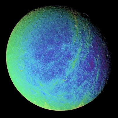 Rhea, from 245.000 Km and in "extreme" false colors...
Bright, wispy markings stretch across a region of darker terrain on Rhea. In this extreme false-color view, the roughly North-South fractures occur within strips of material (which appear greenish here) that are a different color from the surrounding cratered landscape. To create the false-color view, ultraviolet, green and infrared images were combined into a single black and white picture that isolates and maps regional color differences. Most of the large-scale variations in brightness across the surface are removed by this process. This color map was then superimposed over a clear-filter image. The origin of the color differences is not yet understood, but it may be caused by subtle differences in the surface composition or grain sizes making up the icy soil. Wispy markings were seen on the trailing Hemispheres of both Rhea and Dione, in images taken by Voyager spacecrafts, and were hypothesized by some researchers to be the result of material extruded onto the surface by ice volcanism. 
Parole chiave: Saturn's Moons - Rhea