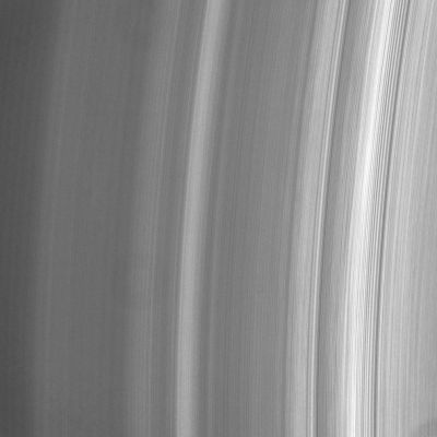 Different Light, Different Brightness, Different Motion...
Caption NASA:"This close-up view of the inner A-Ring shows intriguing variations in brightness along the direction of the Ring motion - from top to bottom. Close examination reveals dark regions that appear to widen and then narrow, and thin bright regions that disappear altogether. 

Variations in brightness are to be expected in the direction of increasing orbital distance from Saturn, but variations along the azimuthal (or circumferential) direction are unusual, as they should be smoothed out quickly by ring particle motion. 

Note: the faint "doughnut" left of center and the dark area in the lower right corner are imaging artifacts.

The image was taken in visible light with the Cassini spacecraft narrow-angle camera on July 23, 2006 at a distance of approx. 285.000 Km (about 177.000 miles) from Saturn. Image scale is about 1 Km (0,6 mile) per pixel".
Parole chiave: Saturn's Rings