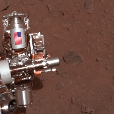 The "American Flag" on the arm of Spirit - Sol 34 (approx. true colors; credits: NASA)
L'immagine che Vi proponiamo relativamente al Sol 34 di Spirit (il quale è appena 'guarito' della sua misteriosa malattia...) fa parte di un trittico a colori approssimativamente veri che ci racconta delle operazioni di pulizia e lucidatura di Adirondack da parte delle spazzole di cui il braccio del Rover è munito. Spicca, sul braccio di Spirit, la Bandiera Americana. 
E' chiaro, a questo punto, che se i colori dell'American Flag sono realistici  (così come ci dicono alla NASA), ne deve conseguire necessariamente che anche i colori dello sfondo lo sono...Giusto?!?

Caption NASA originale:"This image shows the MER Spirit's 'hand', or the tip of the instrument deployment device, poised in front of the rock nicknamed Adirondack. In preparation for grinding into Adirondack, Spirit cleaned off a portion of the rock's surface with a stainless steel brush located on its RAT, seen here at the top of its hand. The image was taken by the Rover's PanCam".
Parole chiave: Postcards from Mars