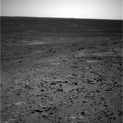 Horizon - Sol 261 (RAW Frame)
Un'orizzonte (apparentemente) luminoso e sterminato; un paesaggio fatto (sempre ed almeno in apparenza) solo di sabbia e sassi che ricorda il deserto del Nuovo Messico o del Nevada. Marte, insomma. 
Siamo nel 261mo Sol di permanenza del Rover Spirit sul Pianeta Rosso e le istantanee di cui abbiamo preso visione sino ad oggi ci consentono di avere un'idea abbastanza precisa circa l'Area Gusev Crater. 

Purtroppo però, la maggior parte (anzi, quasi la totalità...) delle immagini sono in b/n e questo, da svariati punti di vista, non ci ha aiutato. Ancora non riusciamo a capire, per esempio, le condizioni di luminosità di Marte durante il giorno. 
Si tratta, se ci pensate sopra attentamente, di un'informazione decisamente importante, specie in previsione di una possibile permanenza umana (e di lunga durata) sul Pianeta Rosso. L'adattamento dei nostri occhi a condizioni di luminosità sostanzialmente diverse da quelle della Terra (anche in termini di "colore di fondo" dominante) potrebbe essere un problema di non facile soluzione. 
Vi sembra una sciocchezza? Molti credono che sia più difficile abituarsi a condizioni di luminosità superiori alla norma (come quando si va in montagna, ad esempio) ma, in realtà, la soluzione contro la luce "troppo intensa" è facile: basta un paio di occhiali da Sole ed il gioco è fatto. Ma che cosa si può fare se, invece, il problema è diametralmente opposto? Accendiamo una lampada? E poi non dimenticate la cosiddetta "colorazione di fondo"! Sulla Terra la luminosità di fondo è, per quanto ne sappiamo (ma un buon ottico e/o un oculista saprebbero essere molto più precisi), tendente al "bianco". Su Marte, se fosse vero quello che le immagini a colori "almost true" sembrano dirci, la "colorazione di fondo" potrebbe essere MOLTO DIVERSA. C'è chi dice arancio brillante; chi giallo intenso; chi rosso/rosa e così via. Ora, la nostra capacità di percepire i colori dipende non solo dalla luminosità di fondo in quanto tale (che può essere maggiore o minore), ma anche dalla colorazione che questa luminosità di fondo assume. 
Onestamente noi non crediamo che sia uno scherzo abituarsi a vivere in un mondo in cui, ad esempio, TUTTO ciò che vediamo viene ad assumere una nuova colorazione di base (o di fondo) la quale - magari - è tendente al rosa, o al giallo, o all'arancione... 

E questo non è certo il maggiore dei problemi, anzi: pensate alla temperatura superficiale di Marte. Siamo ancora in alto mare ed i dati che i Tecnici del Controllo Missione ci mettono a disposizione (anche se pochi accennano a questo fatto) sono FORTEMENTE DISCUTIBILI.
Quello che intendiamo dire, insomma, è che molte - forse anche troppe - domande (anche quelle che ci sembrano essere le più banali) sono ancora lontanissime dal trovare una risposta almeno soddisfacente e questa risposta, secondo noi, non potrà essere MAI trovata usando solo dei mezzi meccanici. 

Ripetiamo: l'Uomo NON E' totalmente sostituibile e qualche rischio, se si vuole conquistare un "Nuovo Mondo", bisogna rassegnarsi a correrlo!...
Parole chiave: Mars Panorama