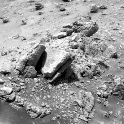 The unusual outcrop and the disappearing light (6)
Sono le 11:28:54 MLT; occhio Dx della NavCam; filtro/colore n. 2. La macchia di luce è proprio sparita. Le spiegazioni possibili non sono tante: la prima e la più razionale (anche se - secondo noi - la meno convincente) attiene il cambio di prospettiva. In altre parole, ciò che l'occhio Sx del PanCam è riuscito e vedere, non è visibile dal suo occhio Dx. 
La seconda spiegazione ci dice che il Sole si è spostato ed i raggi di luce che prima passavano direttamente da un buco posto sulla roccia posta al di sopra del pietrone quasi-rettangolare adesso non possono più farlo. 
E' possibile ma, secondo noi, avremmo dovuto vedere la macchia di luce rimpicciolirsi e non sparire subitaneamente (tenete presente che tra il fotogramma in cui la macchia di luce si vede - ed anche piuttosto bene - ed il frame in cui la macchia scompare passano 34").
Parole chiave: Mars rocks, sand and debris - Controversial image