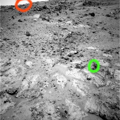 New outcrop and Panorama (3) - Sol 550
Portate l'immagine sino al full size e poi guardate...

Cerchiatura verde: c'è un corpo anomalo verticale, di colore scuro (nero?) che sbuca dal suolo. Alla sua base, vediamo almeno 2 evidenti (diremmo addirittura dilettantistiche...) cancellature. Impossibile dire quale fosse la finalità dell'abrasione.

Cerchiatura rossa: si vede un corpo scuro, di forma quasi perfettamente circolare, che sembra poggiare sul margine dell'orizzonte visibile. Potrebbe anche trattarsi di un photo-artifact, ma noi opteremmo per un oggetto reale (un sasso, forse, dalla forma decisamente inusuale). 
Da guardare con attenzione, inoltre, quelle forme apparentemente appuntite che coprono le sommità di colline/rilievi posti in lontananza, dietro il margine del primo orizzonte (quello su cui poggia la sfera scura, tanto per essere chiari). 
Potrebbe trattarsi di grandi outcrops decisamente sfuocati, ma non ci sentiamo di escludere ipotesi alternative...
Parole chiave: Mars rocks, sand and debris