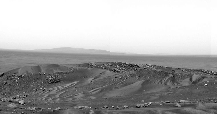 View from the Summit: the rim of Thira Crater and the Eastern Horizon - Sol 582
This panorama is one of the first that NASA's Spirit Rover snapped upon reaching the summit of Husband Hill, located in the Columbia Hills - Gusev Crater, Mars. It reveals the vast landscape to the East previously hidden behind the Columbia Hills. The rim of "Thira Crater" frames the distant horizon some 15 Km (about 9,3 miles) away. 
The Summit area is divided by a shallow saddle that slopes North (left) into an area called Tennessee Valley. Large amounts of sandy material have been blown up the valley and across the saddle in the left-to-right direction, creating the rippled piles of sand seen in this image. 
The science team will examine bedrock and other materials in the summit area to determine their composition and the orientation of the rock layers. These and other observations will provide clues to how the rocks formed and how the hills were sculpted in the geologic past. 
This mosaic was taken by Spirit's PanCam, using the blue filter of its right eye".
Parole chiave: Mars Panorama