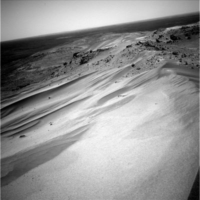 Beautiful Panorama: sand-dunes, boulders and far distant horizon (2) - Sol 605
Prosieguo della panoramica iniziata con il frame precedente. Un solo rilievo, di ordine meramente visivo: da notare le diverse gradazioni di colore che caratterizzano le dune che vanno a formare questa sorta di declivio che dovrebbe portare alle pendici della collina. Non si tratta, a nostro parere, di semplici chiaro-scuri determinati da ombre e filtri/colore: le sabbie, le dune che si vedono in questi frames secondo noi mostrano delle "sfumature" che costituiscono vere e proprie variazioni di colore (pensate ai "seeps" ed a tante immagini orbitali MGS le quali ci hanno dimostrato che, in svariate circostanze (e per cause ancora ignote), le sabbie che coprono le fiancate di colline e piccoli rilievi si "tingono" a strisce di diversi colori (i quali vanno dal giallo chiaro all'arancio e sino al marrone scuro). 

Ipotizziamo: diversa composizione chimica delle sabbie? 
O forse si tratta di fenomeni di ossidazione resi disomogenei dall'azione di vari agenti atmosferici (venti su tutti)?
Parole chiave: Mars Panorama - Postcards from Mars