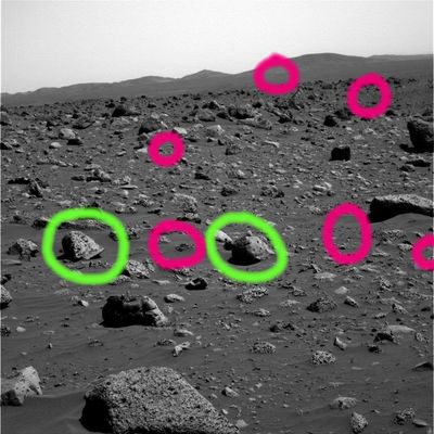 Boulder field (4) - Sol 738
Cerchiature Verdi: due rocce davvero curiose e, in particolare, in quella più a Dx, sembra intuirsi la presenza di almeno due alterazioni digitali (una sulla sua stessa superficie ed un'altra a ridosso di una seconda roccia, di colore scuro e leggermente più lontana, visibile sulla Sx del macigno maggiore - che la eclissa parzialmente).

Cerchiature Fucsia: pseudo photo-artifacts. Molti pensano che si tratti di dead-pixels o di vizi veri e propri dell'immagine causati da una lacuna di segnale (pixels non trasmessi o "persi" in itinere). 
Può essere, certamente; così come può anche essere che si tratti di corpuscoli rocciosi molto luminosi - tipo cristalli - che, nei frames Spirit, appaiono (per motivi legati al tipo di filtro/colore usato, oppure ai tempi di ripresa, o magari a causa delle condizioni di luce effettive in loco al momento dello scatto et sim.) come "sparks". Purtroppo non abbiamo elementi sufficienti per operare una scelta decisa e definitiva.
Ad ogni modo, sulla base della nostra esperienza e sensibilità, saremmo portati a dire che si tratta (QUASI sempre) di photo-artifacts. 
Parole chiave: Mars Panorama - Rocks, Outcrops and Boulders