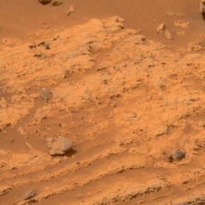 More Layers at Home Plate - Sol 754 (approximate true colors; credits: NASA)
Caption originale:"This view of layers around the edge of a low plateau called Home Plate, inside Mars' Gusev Crater includes a feature that may be what geologists call a "bomb sag" and interpret as evidence of an explosive event, such as a volcanic eruption. 

The layers seen here are generally straight and parallel except in the lower right, where they dip around a greyish rock that is about 4 cm (such as about 1,5") in diameter. When layered deposits are struck by a falling rock while the layers are still soft, this type of pattern can be created. The rock might have been lofted by a volcanic burst or as part of the material ejected by the crater-forming impact of a meteorite.

The PanCam on NASA's MER Spirit acquired the exposures for this image on Spirit's 754th Sol (Feb. 15, 2006). This view is an approximately true-color rendering mathematically generated from separate images taken through all of the left Pancam's 432- to 753-nnmt filters".
Parole chiave: Martian Surface - Home Plate layers