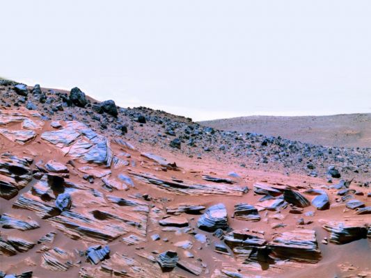 Home Plate in false (but nice) colors - Sol 759
Spirit got its first view of Home Plate last August (2005), after cresting Husband Hill. It took the Rover 94 Martian Days, or Soles, to drive the 848 mt (about 2.782 feet, a little more than half a mile) of the formation. In all, the golf cart-sized Rover has driven about 4 miles across the surface at Gusev. The rocks and geologic characteristics of Home Plate are like no other found by either MER in the 25 months they have been rolling over the Red Planet. 
Steve Squyres, the Mission's Principal Investigator, took time out from his hectic schedule to answer a few quick questions about the rock formation and about the overall status of the Rovers:
Space Daily:
The Home Plate rocks look like a volcano had rained down debris in the middle of water-sculpted strata.

Steve Squyres:
Well, that's an interesting interpretation, but we're a long way from having an answer yet.

SD:
Does anybody on the team have any idea how such markedly different rocks could lie in such close proximity?

SS:
There are a bunch of possibilities: Impact deposits, volcanic deposits, maybe wind- or water-lain sediments. In the images we have so far, the rocks look to some of us like they might be explosive volcanic deposits, but that's purely conjecture at this point - a working hypothesis. Everything is on the table until we've gotten more data down.

SD:
The rovers seem to be impervious to the Martian environment. Are they giving any signs of breaking down, or might they still be working when the Mars Science Laboratory lands in a few years?

SS:
They are not showing signs of breaking down. They are showing definite signs of age, but all the signs of age so far are ones that we can work around. So they're still very capable vehicles.

Of course, that could change at any time. We are 'waaay' past warranty on these vehicles, and there is no telling when they will die. It could be two years or now, or it could be tomorrow. So we treat each day as a gift.

As for the MSL, it's going to land in 2010 if all goes well, more than four years from now. If either MER rover is still alive when that happens, I will be very surprised.

Parole chiave: Mars Panorama - Home Plate Area