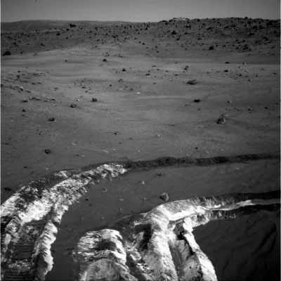 Salt and Sufates? - Sol 787
While driving eastward toward the northwestern flank of McCool Hill, the wheels of NASA's MER Spirit churned up the largest amount of bright soil discovered so far in the mission. This image from Spirit's NavCam, taken on the Rover's 787th Sol of exploration (March 21, 2006), shows the strikingly light tone and large extent of the deposit. A few days earlier, Spirit's wheels unearthed a small patch of light-toned material informally named Tyrone. In images from Spirit's PanCam, Tyrone strongly resembled both Arad and Paso Robles, such as 2 patches of light-toned soils discovered earlier in the mission. Spirit found Paso Robles in 2005 while climbing Cumberland Ridge, on the western slope of Husband Hill. In early January 2006, Sptirit discovered Arad on the basin floor just south of Husband Hill. Spirit's instruments confirmed that those soils had a salty chemistry dominated by iron-bearing sulfates. Spirit's miniature thermal emission spectrometer is analyzing this most recent discovery, and researchers will compare it with those other deposits. 

These discoveries indicate that light-toned soil deposits might be widely distributed on the flanks and valley floors of the "Columbia Hills" region in Gusev Crater on Mars. The salts may record the past presence of water, as they are easily mobilized and concentrated in liquid solution.

Parole chiave: Martian Surface - possible salt and carbonate underground deposits