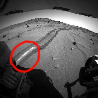 In the "salty" kingdom (4) - Sol 799
Un'immagine ulteriormente curiosa ed ambigua: Spirit, a quanto sembra vedersi in questa ripresa, non ha scavato per evidenziare il bianco che appare nella cerchiatura rossa. La traccia che vediamo in questo frame, in effetti, sembra più riferirsi ad un qualcosa che è stato schiacciato dalle ruote di Spirit e che, nel frantumarsi, ha lasciato una striscia biancastra.
Insomma: se nei frames precedenti il sale ed i solfati venivano portati alla luce da un'attività di scavo, qui lo scavo non pare esserci stato e allora... E allora (forse):
1. il materiale bianco che vediamo ora NON è il medesimo che è stato portato alla luce e ripreso in precedenza oppure 
2. non tutti i sali e solfati (o carbonati etc.) giacciono effettivamente al di sotto della superficie e sono rinvenibili solo in forma di polveri oppure
3. la natura del suolo su cui Spirit si sta muovendo è molto più complessa di quanto sino ad ora compreso od ipotizzato.
Parole chiave: Martian Surface - Controversial