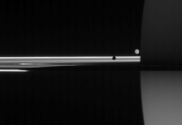 One in the Shadows, one in the Lights
Caption NASA originale:"The unlit side of the Rings glows with scattered Sunlight as two moons circle giant Saturn. The light reaching Cassini in this view has traveled many paths before being captured. 
At left, Mimas (397 Km, or 247 miles across) presents its "Dark Side". Enceladus (505 Km, or 314 miles across), on the Far Side of the Rings, is lit by "Saturnshine," or reflected sunlight coming from the planet. Saturn, in turn, is faintly lit in the south by light reflecting off the Rings. 

Saturn's shadow darkens the Rings, tapering off toward the left side of this view. 

The image was taken in visible light with the Cassini spacecraft narrow-angle camera on June 11, 2006 at a distance of approx. 3,9 MKM (about 2,5 MMs) from Mimas, 4,3 MKM (approx. 2,7 MMs) from Enceladus and 4,1 MKM (about 2,6 MMs) from Saturn. 
Image scale is roughly 25 Km (approx. 16 miles) per pixel on Saturn".
Parole chiave: Saturn and Companions