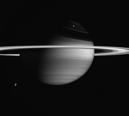 Saturn, Titan, Rhea and Enceladus
Caption NASA originale:"Saturn's biggest and brightest moons are visible in this portrait by Cassini. 
Titan (5.150 Km, or 3,200 miles across) is Saturn's largest moon and appears at the lower left. Note that some details in the moon's smoggy atmosphere are visible here. Rhea (1.528 Km, or 949 miles across) is the planet's second largest moon and is seen above center. Enceladus (505 Km, or 314 miles across) has the brightest surface in the solar system, reflecting nearly all of the sunlight that falls upon it. Enceladus is just above the rings, left of center. Titan was on the far side of the planet at the time of this exposure, while the other moons were on the near side, much closer to Cassini. 
Also seen here are details in the cloud bands of Saturn's mostly hydrogen atmosphere, variations in brightness across the dazzling rings and magnificent ring shadows cast upon the northern hemisphere. The image was taken with the Cassini spacecraft wide-angle camera on Feb. 5, 2005, at a distance of approximately 3.4 million kilometers (2.1 million miles) from Saturn through a filter sensitive to wavelengths of infrared light centered at 728 nanometers. The image scale is 200 kilometers (124 miles) per pixel".
Parole chiave: Saturn and Companions