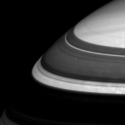 Cassini, Encke and Keeler: bright arcs in the shadow of the Rings
Saturn's Rings throw imposing shadows and relegate parts of the Planet's Northern Regions to darkness. Three thin and bright arcs in this scene represent three well-known gaps in the immense Ring System. From bottom to top here (and widest to thinnest) they are the Cassini Division, the Encke Gap and the Keeler Gap. 
The image was taken in infrared light (752 nnmts) using the Cassini spacecraft wide-angle camera on Oct. 29, 2005, at a distance of approximately 446.000 Km (about 277.000 miles) from Saturn. 
The image scale is 23 Km (roughly 14 miles) per pixel. 
The image was contrast enhanced to improve visibility of features in the atmosphere.
Parole chiave: Saturn