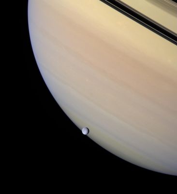 Saturn and Rhea
Caption NASA:"A serene orb of ice is set against the gentle pastel clouds of giant Saturn. Rhea transits the face of the gas giant, whose darkened Rings and their planet-hugging shadows appear near upper right. 
Rhea is the second largest of Saturn's moons. 
This view looks toward the unilluminated side of the Rings from about 3° above the Ring-Plane. 

Images taken using red, green and blue spectral filters were combined to create this natural color view. The view was acquired with the wide-angle camera on Feb. 4, 2007. Cassini acquired the view at a distance of approx. 1,2 MKM (about 700.000 miles) from Saturn and approx. 679.000 Km (about 422.000 miles) from Rhea. 
Image scale is roughly 68 Km (about 42 miles) per pixel on Saturn and about 40 Km (about 25 miles) per pixel on Rhea". 
Parole chiave: Saturn and Companions