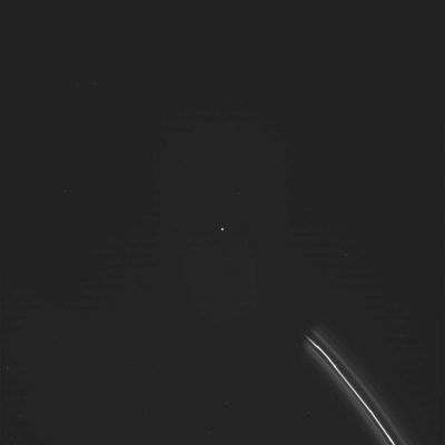 Spark in the Dark! (possible Anomaly)
Cassini sta viaggiando nel cono d'ombra generato da Saturno e quindi, se il 'volto di Saturno' sta guardando il Sole, noi possiamo pure dire che Cassini è 'alle spalle' del Gigante Anellato.
Ciò premesso, riusciamo comunque a vedere una porzione dell'Anello F  (ancora illuminato da Sole e davvero caratteristico ed inconfondibile per i suoi 'clumps'!) sull'estrema Dx dell'immagine mentre, proprio al centro del frame, distinguiamo chiaramente un corpo luminoso sferico e svariati altri puntini luminosi e svariati graffi. Sui 'puntini luminosi' ed i 'graffi', la nostra esperienza in campo di fotografia astronomica e spaziale ci dice che si tratta di semplici photo-artifacts. Il punto luminoso centrale, invece, secondo noi NON lo è. 
Ora, dato che stiamo guardando in una regione immersa nell'ombra di Saturno (e dunque nel buio), quel punto - se effettivamente NON è un photo-artifact - NON può neppure essere una delle Lune Saturniane!

E allora che cos'è?
Parole chiave: Saturn's Rings - The F-Ring - Controversial Image