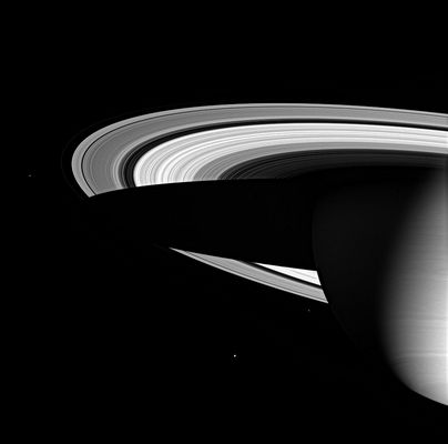 Saturn's Space Panorama
Caption NASA originale:"Three of Saturn's icy moons are seen here, along with the magnificent water-ice rings and the cold gaseous envelope of the Planet's atmosphere. Saturn's dark shadow stretches completely across the rings. 
At nine and a half times farther from the Sun than Earth, Saturn inhabits the deep cold of the outer Solar System. The Sun appears only 1% as bright there as it appears at Earth, creating an environment where ice dominates over rock. 
The icy Moons visible here, from left to right are: Janus (181 kilometers, or 113 miles, across), Enceladus (505 kilometers, or 314 miles, across), and Epimetheus (116 kilometers, or 72 miles, across). 
The image was taken in visible green light with the Cassini spacecraft wide-angle camera on June 1, 2005, at a distance of approximately 2,4 MKM from Saturn. The image scale is 139 Km per pixel".
Parole chiave: Saturn and Companions
