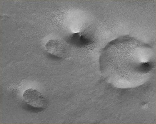 Hills, Knobs and Buried Craters in the South Polar Region (Original NASA/MGS/MSSS b/w Frame)
Original caption:"This MGS-MOC image shows a Summer scene from the South Polar Region of Mars. The circular feature in the North-East (upper right) corner of the image is an old meteor impact crater that has been partially filled and buried. The cone-shaped hill that occurs within the crater on its East (right) side is a remnant of material that once covered and completely buried the crater. Perhaps beneath the surfaces in the rest of the image there are other craters that have been filled and buried such that we cannot know, from an image, that they ever existed. The theme of filled, buried, and exhumed craters is one that repeats itself —over and over again — all over Mars".

Location near: 80,3° South Lat. and 286,1° West Long.  
Image width: ~3 Km (~1,9 mi)  
Illumination from: upper left  
Season: Southern Summer
Parole chiave: Mars from orbit - South Polar Features - Hills & Knobs