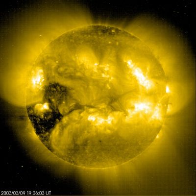 Coronal "Holes"
Caption NASA originale:"The ominous, dark shapes haunting the left side of the Sun are coronal holes - low density regions extending above the surface where the solar magnetic field opens freely into interplanetary space. Studied extensively from space since the 1960s in ultraviolet and x-ray light, coronal holes are known to be the source of the high-speed solar wind, atoms and electrons which flow outward along the open magnetic field lines. During periods of low activity, coronal holes typically cover regions just above the Sun's poles. These coronal holes, however, have just moved into view near the Sun's equator, and particles escaping them have already caused notable aurora here on Earth. Coronal holes like this one may last for a few solar rotations before the magnetic fields shift and change configurations. Shown in false-color, this picture of the Sun on March 9, 2003, was made in extreme ultraviolet light by the EIT instrument on board the space-based SOHO observatory".
Parole chiave: The Sun