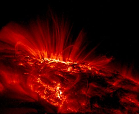 The Sun from TRACE in ultra-violet light
Caption NASA originale:"Shown in ultraviolet light, the relatively cool dark regions have temperatures of thousands of degrees Celsius. Large sunspot group AR 9169 is visible as the bright area near the horizon. The bright glowing gas flowing around the sunspots has a temperature of over 1.000.000° C. The reason for the high temperatures is still unknown but thought to be related to the rapidly changing magnetic field loops that "channel" solar plasma. 
Sunspot group AR 9169 moved across the Sun during September 2000 and decayed in a few weeks".
Parole chiave: Sunspot Loops