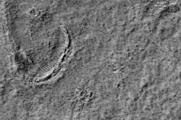 Niger Vallis
This image shows a portion of the floor of Niger Vallis, an ancient Martian outflow channel. Niger Vallis originates on the flanks of the volcano Hadriaca Patera, and empties into the Hellas impact basin. Outflow channels are observed in many regions of the planet, and may have been carved by brief eruptions of liquid water from beneath the surface. Since Niger Vallis formed, impacts have cratered the channel floor, and fine-grained wind-blown debris has been transported across the surface, eroding and burying all but the freshest craters. The curved ridge in the scene may be the remnant of a large crater rim. At the high resolution of this image, a pattern of parallel dunes and ripples can be seen, as well as individual boulders as large as two meters across. 


Parole chiave: Mars from orbit - Niger Vallis