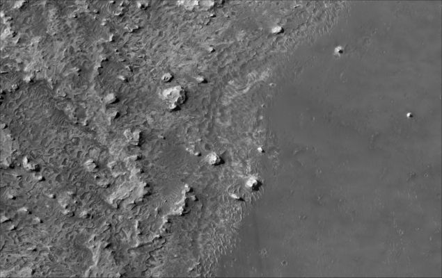Meridiani Planum
This HiRISE image shows geologic "contacts", or boundaries, between light-toned and dark-toned material in Meridiani Planum, near the equator of Mars. Merdiani Planum is where the Mars Exploration Rover Opportunity is located, although this image covers an area that is more than 600 km to the east of the Opportunity site. The central portion of the image shows very smooth, dark plains that are typical of much of the Meridiani region. These plains are flanked by more rugged lighter-toned materials. The light-toned materials have been eroded to form dramatic pits, buttes and mesas. Based on the lengths of the shadows that they cast, some of the buttes and mesas are up to about 30 meters (~100 feet) tall. The light-toned material shows distinctive layering, suggesting that it may be composed of sedimentary rock. Scattered across the scene, especially in the light-toned materials where they are prominent in low spots and around some of the larger buttes and mesas, are dunes and other similar landforms created by martian winds. 


Parole chiave: Mars from orbit - Meridiani Planum