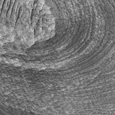 Candor Chasma
Candor Chasma is one of several large troughs that make up Valles Marineris, the largest canyon system in the Solar System. Much of Candor Chasma is filled with layered deposits, like those shown in this HiRISE sub-image. Layers only 1-2 meters thick can be resolved by HiRISE and provide details on the processes that emplaced and modified these sediments. The layered deposits could be volcanic, lacustrine, or eolian sediments that filled in some portions of the trough of Valles Marineris. The variations in brightness of the layers could represent compositional differences in the layers or the thickness of overlying debris, such as sand or dust. This area was targeted because minerals rich in sulfur were detected here by the OMEGA instrument on Mars Express. By using HiRISE images to look at specific geologic units that correspond to these locations of sulfate, it may be possible to determine the origin of the sediments, particularly those that contain the sulfates. The paucity of impact craters on the layered deposits suggests either a young age for the sediments or erosion has removed much of the upper layers to reveal a fresher-looking surface. Dark dunes and ripples indicate that wind has been, and still may be, moving debris across the sedimentary deposits.
Parole chiave: Mars from orbit - Candor Chasma (Valles Marineris T.S.) Region