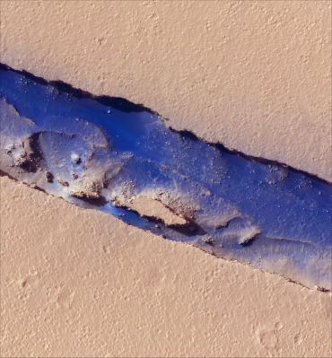 Cerberus' River
The prominent trough in this sub-image (of HiRISE image TRA_000827_1875_IRB ) is a segment of the Cerberus Fossae rift system. In geological terminology the trough is known as a graben, or down-dropped region bounded by faults. In this location the graben is about 300 m wide and 90 m deep. Bright, dust-covered, cratered plains surround the graben, and darker sediments blanket much of its floor. Dunes that vary in size and spacing occur within the darker sediments, and their shapes suggest that the wind typically blows from east to west. Light-toned, angular boulders pepper the darker sediments. They have broken away from the rocky walls of the graben and tumbled downhill. Over time this mass wasting has caused the cliffs to retreat, widening the trough. The somewhat lighter patches of cratered terrain on the graben floor were once level with the surrounding plains, but have since been lowered by faulting. Over time they may become obscured or buried by the darker sediments. High-standing ridgesÑremnants of the former surfaceÑcast jagged shadows on the floor of the graben that reveal the rugged nature of the landscape in this region of Mars. 
Image TRA_000827_1875 was taken by the High Resolution Imaging Science Experiment (HiRISE) camera onboard the Mars Reconnaissance Orbiter spacecraft on September 29, 2006. The complete image is shown below, centered at 7.4 degrees latitude, 168.5 degrees East longitude. The range to the target site was 275 km (171 miles). At this distance the image scale is 55 cm/pixel (with 2 x 2 binning) so objects ~165 cm across are resolved. The image shown below has been map-projected to 50 cm/pixel and north is up. The image was taken at a local Mars time of 3:26 PM and the scene is illuminated from the west with a solar incidence angle of 51.9 degrees, thus the sun was about 38.1 degrees above the horizon. At a solar longitude of 113.7 degrees, the season on Mars is Northern Summer / Southern Winter.

Parole chiave: Mars from orbit - Cerberus Fossae Region