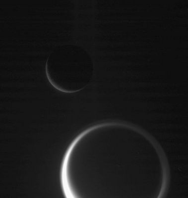 Dancing in the dark
Ghostly details make this dark scene more than just a beautiful grouping of two Saturn moons: Tethys and Titan. 
In Titan's thick and inflated atmosphere, the detached high haze layer can be seen, as well as the complex Northern Polar "hood". Images like this one can help scientists make definitive estimates of the altitudes to which the high haze extends. 
The faint vertical banded pattern is a type of noise that usually is removed during image processing. 
Since this image was processed to enhance the visibility of details in Titan's atmosphere as well as in the faint G-Ring, the vertical noise was also enhanced. 

This view was obtained in visible light with the Cassini spacecraft narrow-angle camera on Jan. 19, 2006, at a distance of approx. 2,4 MKM (such as about 1,5 MMs) from Titan and 1 MKM (about 600.000 miles) from Tethys. The image scale is 14 Km (about 9 miles) per pixel on Titan and 6 Km (about 4 miles) per pixel on Tethys.
Parole chiave: Saturn's Moons - Tethys and Titan
