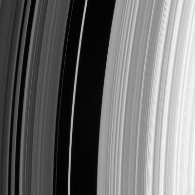 The Huygens "Gap"
Caption NASA:"The sharp outer boundary of Saturn's B-Ring, which is the bright ring region seen to the right in this image, is maintained by a strong resonance with the moon Mimas. For every two orbits made by particles at this distance from Saturn, Mimas makes one orbit. 
The moon's repeated gravitational tugs force ring particles away from this region. 
The dark region is called the "Huygens Gap" and it includes the bright, eccentric Huygens Ringlet, also visible here near center".
Parole chiave: Saturn's Rings
