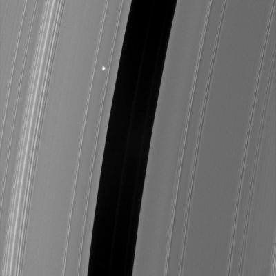 Not the Sun, but Aldebaran!
Caption NASA:"The Cassini spacecraft took a series of images on Sept. 9, 2006 as it watched the bright red giant star Aldebaran slip behind Saturn's Rings. 
This type of observation is known as a stellar occultation and uses a star whose brightness is well known. As Cassini watches the rings pass in front of the star, the star's light fluctuates, providing information about the concentrations of ring particles within the various radial features in the Rings. 

This view shows the Encke Gap (325 Km, or approx. 200 miles wide) and the faint ringlets which share the gap with the embedded moon Pan. The view looks toward the sunlit side of the Rings from about 19° below the Ring-Plane. 
Bright Aldebaran is overexposed, creating thin vertical lines on its image. 

The image was taken in visible light with the Cassini spacecraft narrow-angle camera on Sept. 9, 2006 at a distance of approx. 359,000 Km (about 233.000 miles) from Saturn. Image scale on the sky at the distance of Saturn is 2 Km per pixel".

Nota: la NASA - finalmente - ci fornisce un'informazione contestuale utile e ci permette di correggere un nostro errore interpretativo (del quale ci scusiamo con Voi). Non è dunque il Sole, l'astro che viene occultato dagli Anelli di Saturno, bensì la super-gigante Rossa "Aldebaran". Ottimo: non finiamo mai di stupirci per quello che Cassini riesce a mostrarci!
Parole chiave: Saturn's Rings - The Encke Gap in the "A" Ring