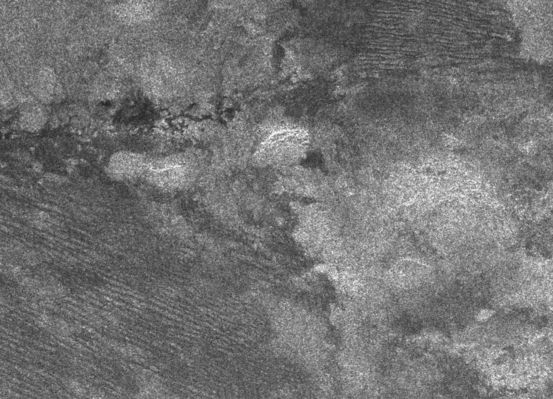 The "Cat Scratches"
Original caption:"The geologic diversity of Titan's surface is well illustrated by this synthetic aperture radar image, obtained on Oct. 28, 2005, during the Cassini spacecraft's 9th Titan fly-by and 4th radar pass. 
The bottom left and top right parts of the image show a series of parallel features resembling those discovered during the second radar pass. Called "cat scratches", these features may be dunes of water ice or hydrocarbon particles. The brighter area on the bottom right is thought to be rougher and possibly higher in elevation than the darker areas. Above the center of the image are dark, narrow winding channels carved by, and possibly still containing, liquids.

This image is about 300 by 250 Km and it is located 10° South Lat. and 292° West Long.".
Parole chiave: Saturn's Moons - Titan