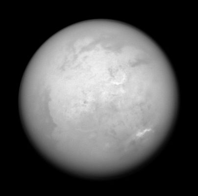 Infrared Titan (from approx. 1,2 MKM)
Caption NASA originale:"Southeast of Xanadu (and above the center in this view) is a peculiar semi-circular feature informally referred to by imaging scientists as "The Smile". This surface feature is the brightest spot on Titan's surface, not only to the Imaging Science Subsystem Cameras, but also to the Visual and Infrared Mapping Spectrometer (VIMS), which sees the surface at even longer wavelengths. "The Smile" is about 560 Km (345 miles) wide. 
At the landing site of the successful Huygens probe mission, brighter regions correspond to icy upland areas, while the darker regions are lowlands that possess a higher proportion of the organic byproducts of Titan's atmospheric photochemistry. Those results seem to confirm the long-standing hypothesis that Xanadu is a relatively high region of less contaminated ice. However, the cause of the even brighter Smile is a mystery that is still under study. Farther South, a field of bright clouds arcs around the Pole, moving at a few meters per second". 
Parole chiave: Saturn's Moons - Titan - Controversial Image