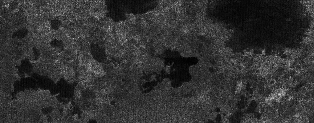 Titanian Northern Lakes (1)
Caption NASA originale:"The Cassini spacecraft, using its radar system, has discovered very strong evidence for hydrocarbon lakes on Titan. 
Dark patches, which resemble terrestrial lakes, seem to be sprinkled all over the high latitudes surrounding Titan's North Pole. 
Scientists have speculated that liquid methane or ethane might form lakes on Titan, particularly near the somewhat colder Polar Regions. In the images, a variety of dark patches, some with channels leading in or out of them, appear. The channels have a shape that strongly implies they were carved by liquid. Some of the dark patches and connecting channels are completely black, that is, they reflect back essentially no radar signal, and hence must be extremely smooth. In some cases rims can be seen around the dark patches, suggesting deposits that might form as liquid evaporates. The abundant methane in Titan's atmosphere is stable as a liquid under Titan conditions, as is its abundant chemical product, ethane, but liquid water is not".
Parole chiave: Saturn's Moons - Titan