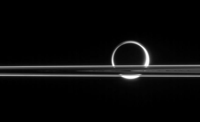 Titan through the Rings
Caption NASA originale:"Titan shines beyond the Rings like a brilliant ring of fire, its light gleaming here and there through the gaps in Saturn's magnificent plane of ice. Titan is surrounded by a thick photochemical haze which scatters the Sun's light. 

The image was taken in visible light with the Cassini spacecraft narrow-angle camera on June 11, 2006 at a distance of approx. 5,3 MKM (about 3,3 MMs) from Titan and at a Sun-Titan-spacecraft, or phase, angle of 158°. Image scale is roughly 32 Km (about 20 miles) per pixel on Titan".
Parole chiave: Saturn's Moons - Titan