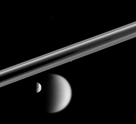 Titan & Co.
Original caption:"In a rare moment, the Cassini spacecraft captured this enduring portrait of a near-alignment of four of Saturn's restless moons. Timing is critical when trying to capture a view of multiple bodies, like this one. All four of the moons seen here were on the far side of the Rings from the spacecraft when this image was taken; and about an hour later, all four had disappeared behind Saturn. 

Seen here are Titan (5.150 Km, or 3.200 miles across) and Dione (1.126 Km, or 700 miles across) at bottom; Prometheus (102 Km, or 63 miles across) hugs the Rings at center; Telesto (24 Km, or 15 miles across) is a mere speck in the darkness above center. 

The image was taken in visible light with the Cassini narrow-angle camera on Oct. 17, 2005 at a distance of approx. 3,4 MKM (2,1 MMs) from Dione and 2,5 MKM (about 1,6 MMs) from Titan. The image scale is 16 Km (10 miles) per pixel on Dione and 21 Km (about 13 miles) per pixel on Titan".
Parole chiave: Saturn's Moons - Titan, Dione, Prometheus and Telesto