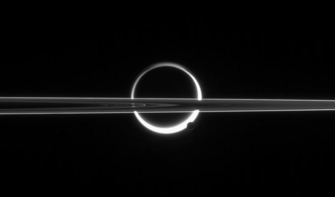 Titan and Enceladus
Caption NASA originale:"Saturn's Rings cut across an eerie scene that is ruled by Titan's luminous crescent and globe-encircling haze, broken by the small moon Enceladus, whose icy jets are dimly visible at its South Pole. North is up. 
The scattered light around planet-sized Titan makes the moon's solid surface visible in silhouette. Enceladus enjoys far clearer skies than its giant sibling moon. 
This view shows the unlit side of Saturn's Rings. 

The image was taken in visible red light with the Cassini spacecraft narrow-angle camera on June 10, 2006 at a distance of approximately 3,9 MKM (about 2,4 MMs) from Enceladus and 5,3 MKM (3,3 MMs) from Titan. The view was obtained at a Sun-moon-spacecraft, or phase, angle of about 160°, relative to both moons. 
Image scale is roughly 23 Km (about 15 miles) per pixel on Enceladus and roughly 32 Km (about 20 miles) on Titan".
Parole chiave: Saturn's Moons - Enceladus and Titan